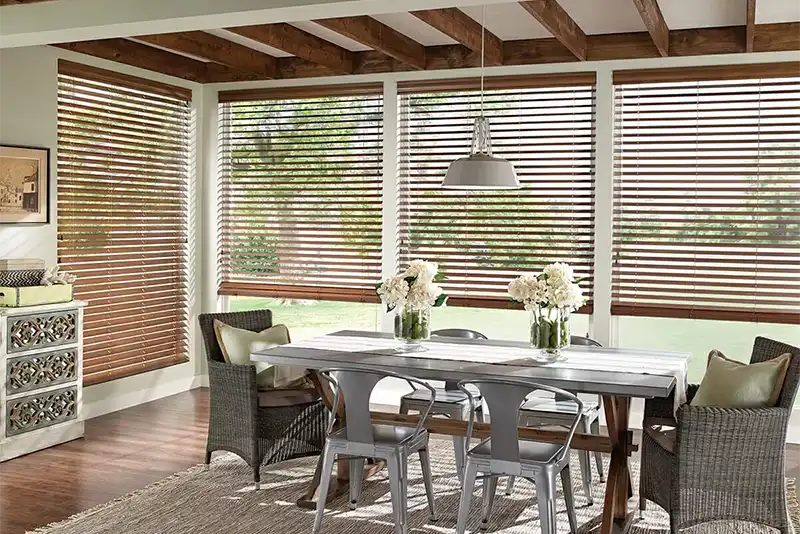 Dining room with custom wooden window shades on large windows